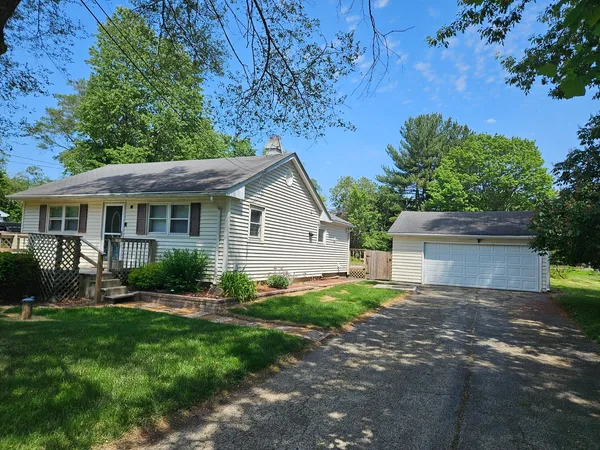 a view of a house with a yard and potted plants