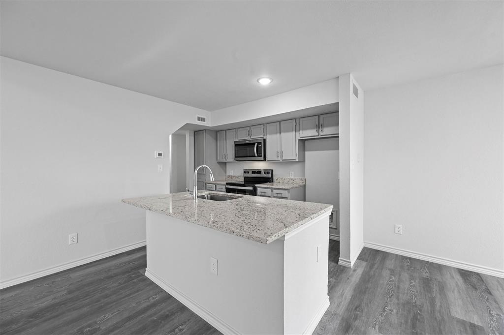 9825 Walnut Street, Unit 206 Dallas, TX 75243 - Photo 13 of 35 a view of a kitchen with center island and stainless steel appliances