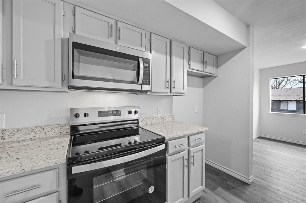 9825 Walnut Street, Unit 206 Dallas, TX 75243 - Photo 19 of 35 a kitchen with stainless steel appliances white cabinets and a stove top oven