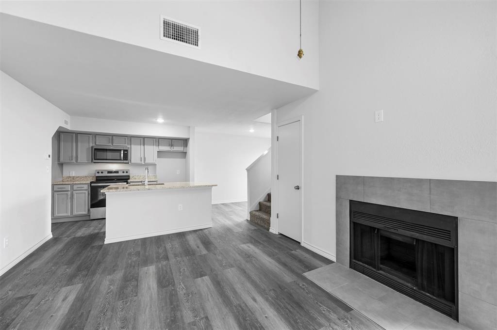 9825 Walnut Street, Unit 206 Dallas, TX 75243 - Photo 10 of 35 a kitchen with stainless steel appliances kitchen island wooden floors and white cabinets