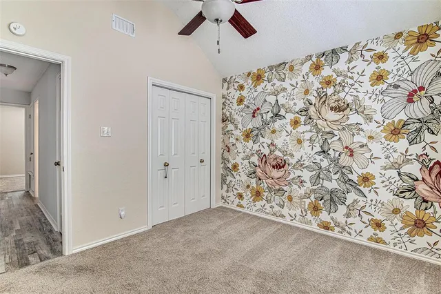 an empty room with a window and a chandelier fan