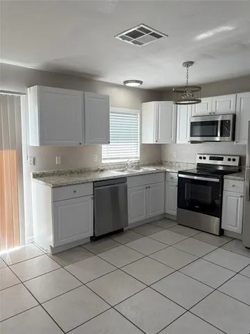a kitchen with stainless steel appliances granite countertop a stove sink and cabinets