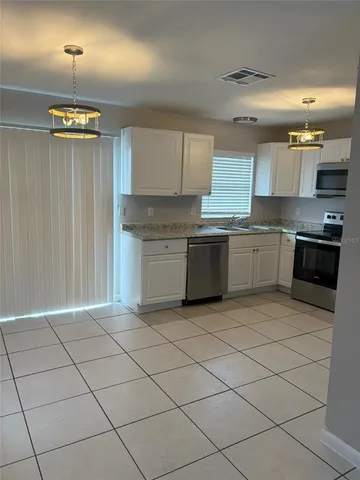 a large kitchen with cabinets and stainless steel appliances