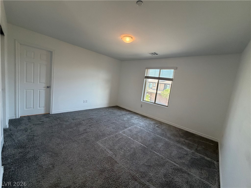 3228 Azalea Ridge Court Henderson, NV 89052 - Photo 13 of 28 Well-lit room with plush carpet, a window with blinds, and a classic paneled door.