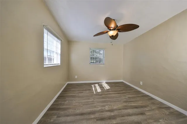 a view of empty room with wooden floor