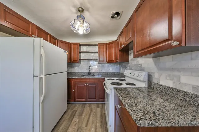 a kitchen with stainless steel appliances granite countertop a refrigerator stove and sink