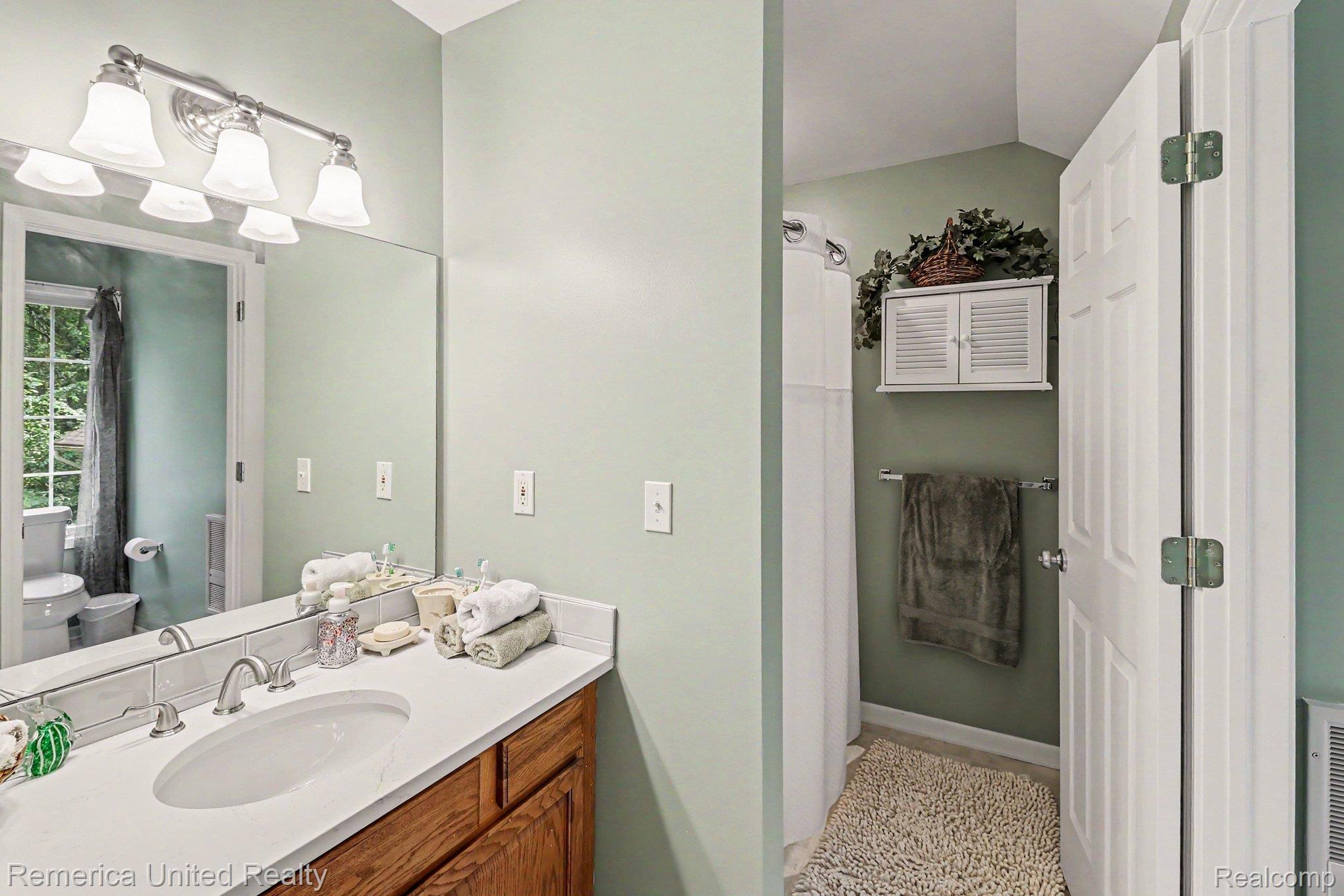 20962 Wasson Road Gregory, MI 48137 - Photo 25 of 39 Bathroom featuring a wide vanity with a built-in sink, neutral countertop, and wood-finish cabinetry