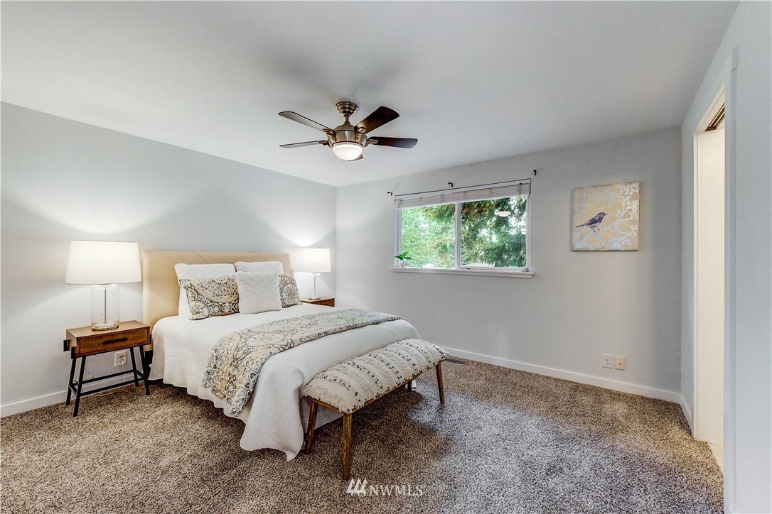 21828 Meridian Avenue South Bothell, WA 98021 - Photo 14 of 31 a bedroom with a bed a chandelier and a window