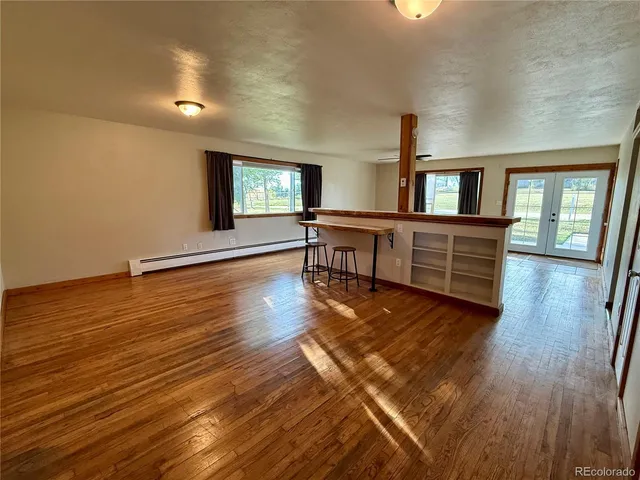 a view of a livingroom with wooden floor and furniture