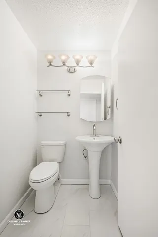 a bathroom with a sink a toilet and a mirror