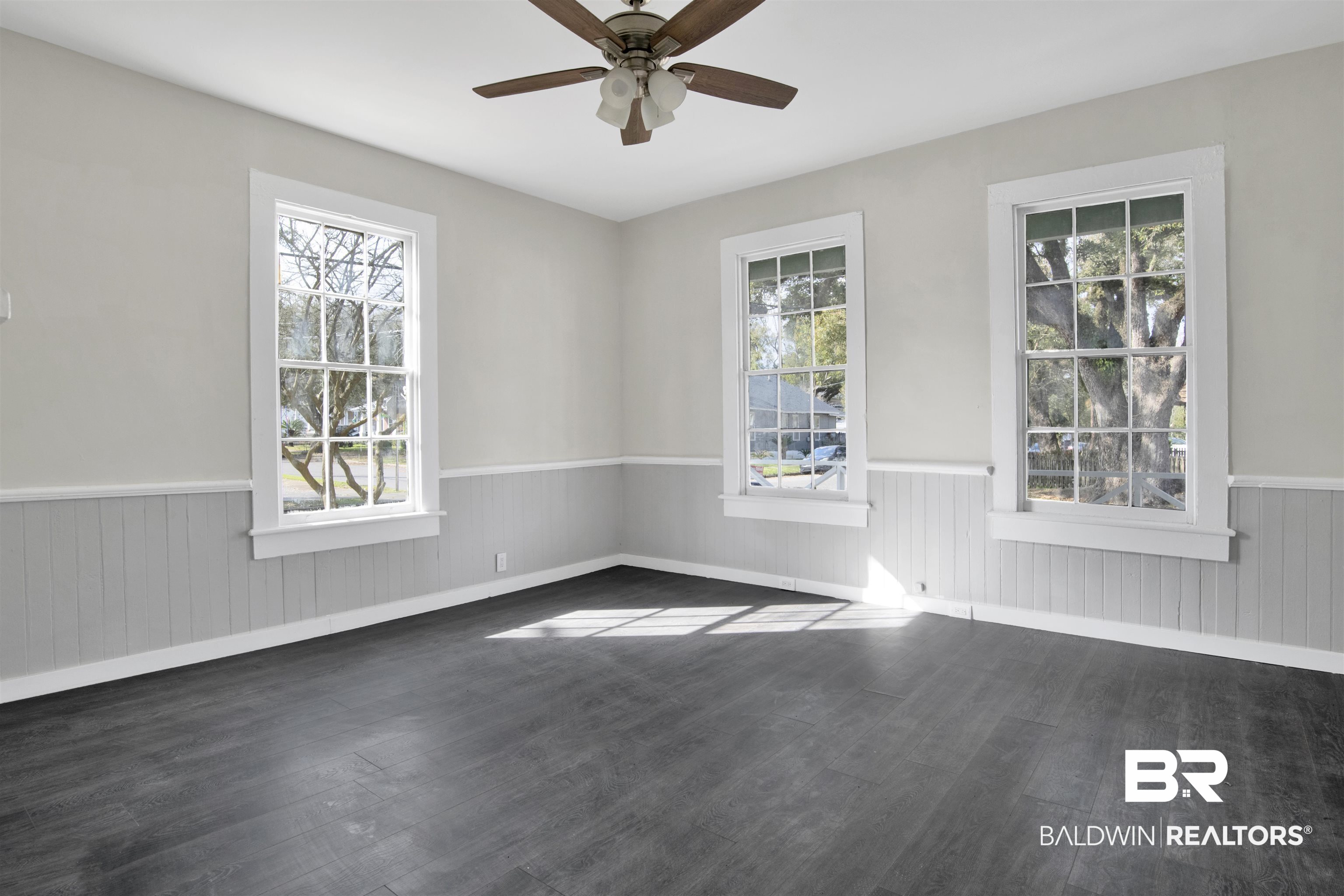 1063 Selma Street Mobile, AL 36604 - Photo 7 of 32 Spare room with a ceiling fan, wainscoting, and dark wood-style floors