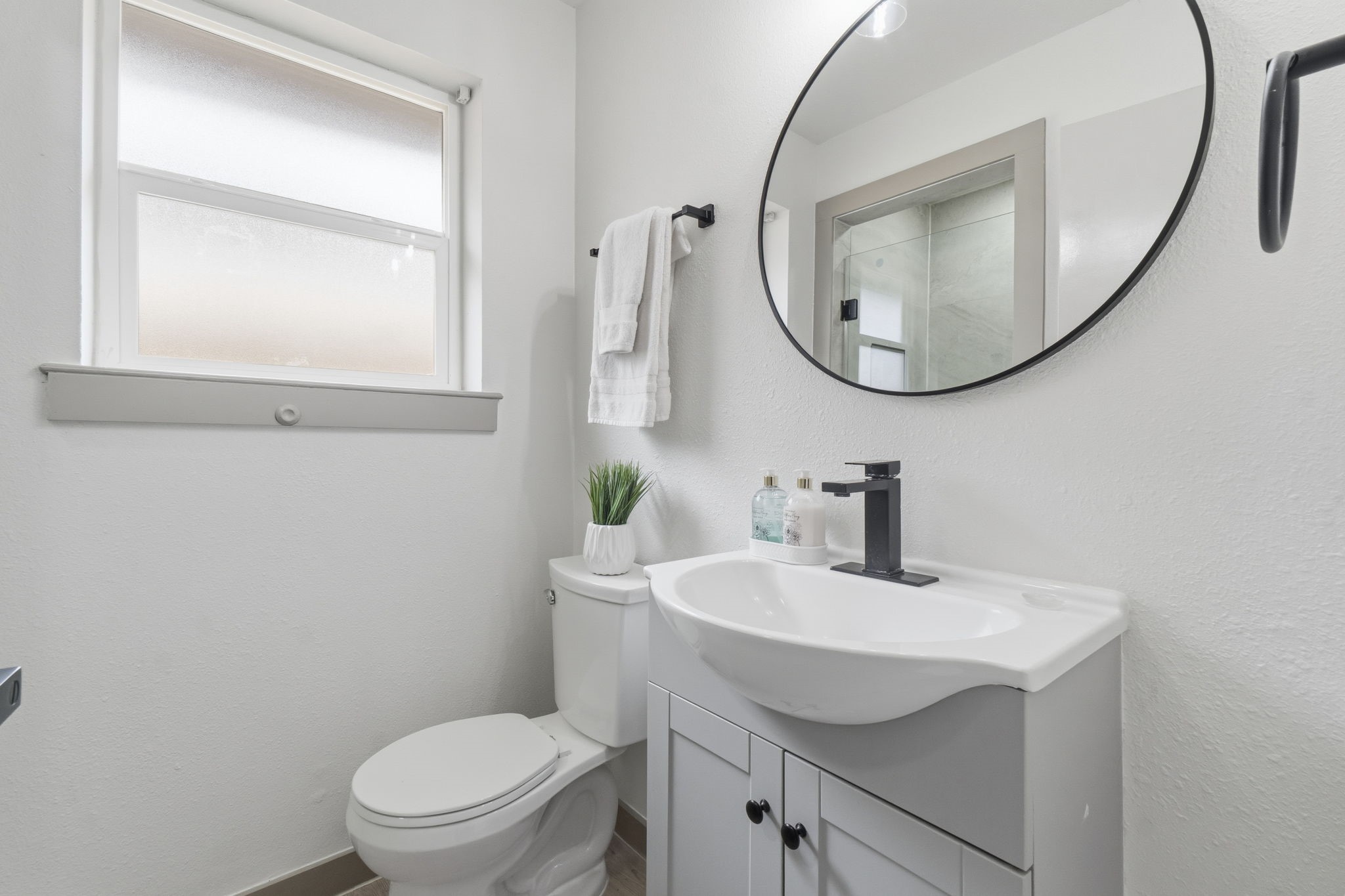 14850 Coaltown Road Willis, TX 77378 - Photo 24 of 41 Stylish primary bathroom featuring modern vanity, updated fixtures, round mirror, and clean contemporary design.