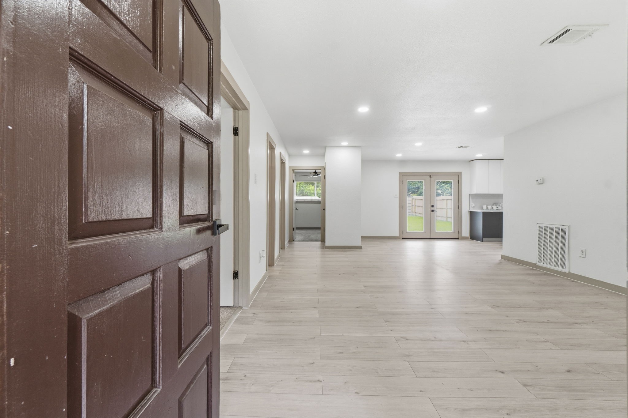 14850 Coaltown Road Willis, TX 77378 - Photo 4 of 41 Bright and airy entry opening into the spacious open-concept living area with light wood-look flooring, recessed lighting, and modern neutral finishes throughout.