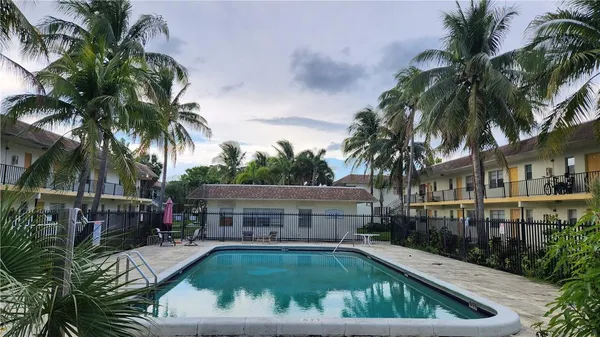 a view of backyard with swimming pool and outdoor seating