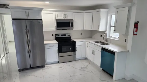 a kitchen with white cabinets and stainless steel appliances