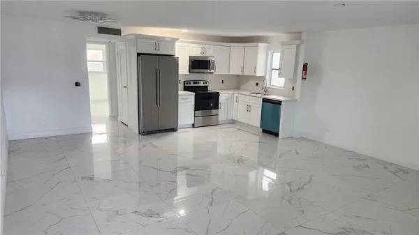a kitchen with stainless steel appliances a refrigerator sink and cabinets