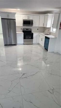 a kitchen with stainless steel appliances a stove a microwave and white cabinets
