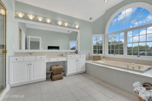 a spacious bathroom with a tub double sink window and mirror