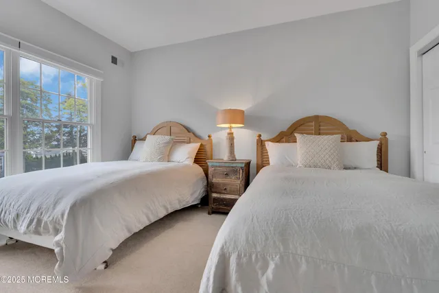 a bedroom with two beds and a window