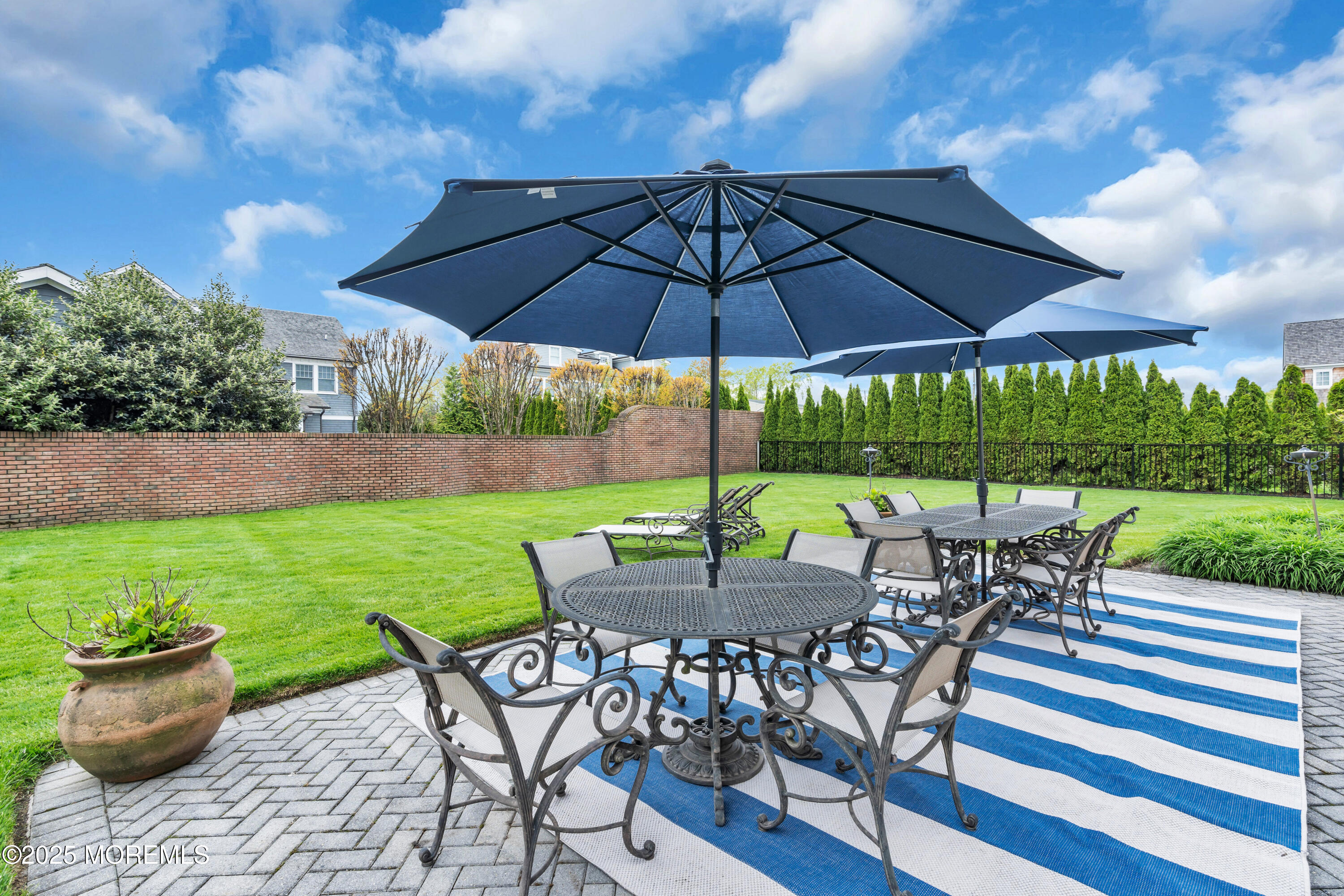 201 Jersey Avenue Spring Lake, NJ 07762 - Photo 3 of 29 a view of a patio with a dining table and chairs under an umbrella