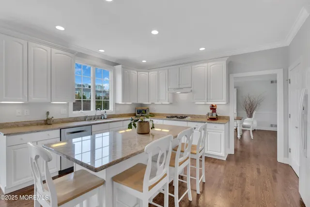 an open kitchen with granite countertop white cabinets and stainless steel appliances