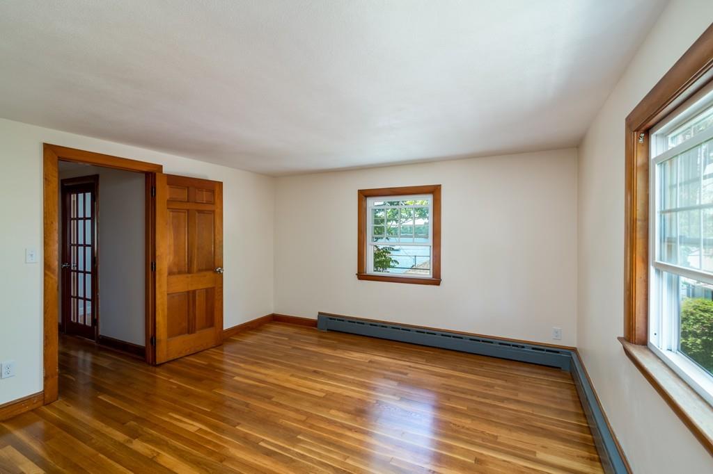 122 Edgewater Road Hull, MA 02045 - Photo 17 of 24 a view of an empty room with wooden floor and a window