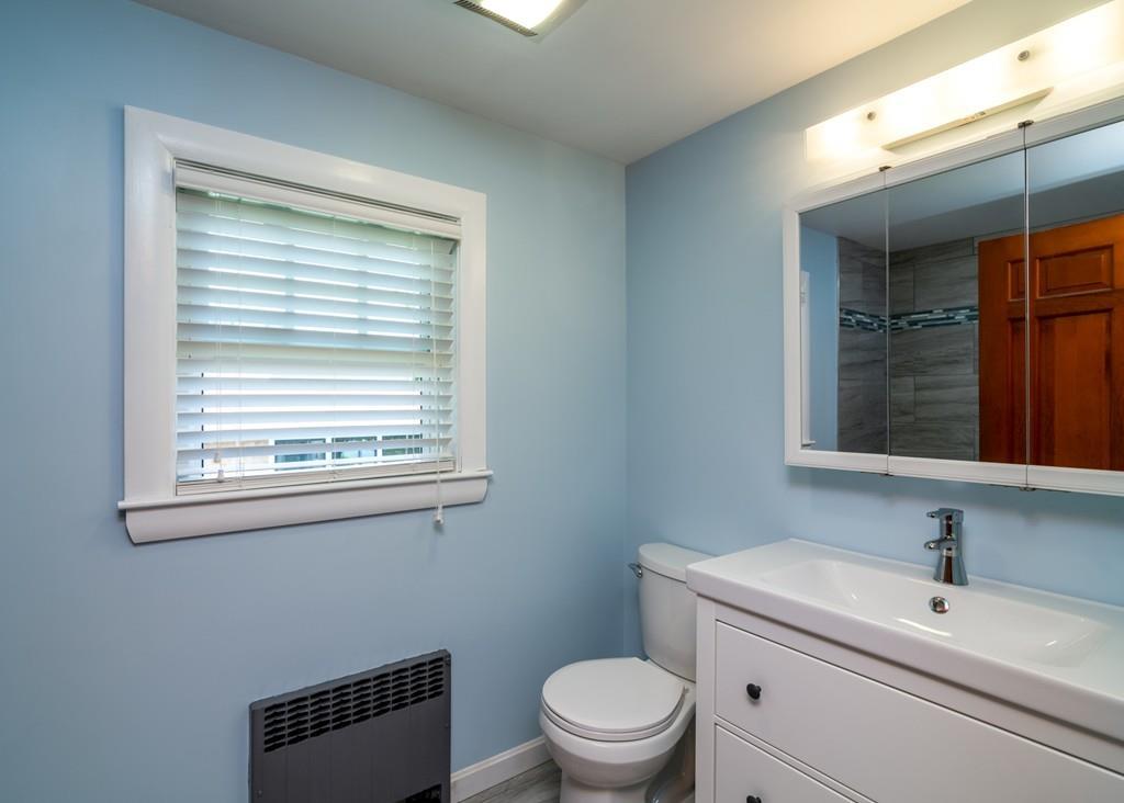122 Edgewater Road Hull, MA 02045 - Photo 18 of 24 a bathroom with a toilet a sink a mirror and a window