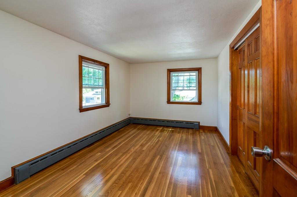 122 Edgewater Road Hull, MA 02045 - Photo 20 of 24 a view of an empty room with wooden floor and a window