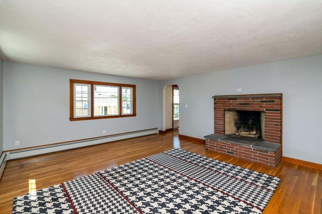 122 Edgewater Road Hull, MA 02045 - Photo 6 of 24 a view of an empty room with a fireplace and a window