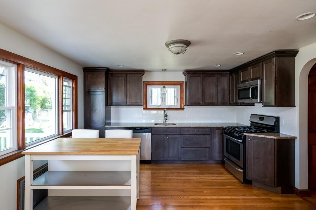 122 Edgewater Road Hull, MA 02045 - Photo 9 of 24 a kitchen with stainless steel appliances granite countertop wooden cabinets a stove top oven a sink and dishwasher