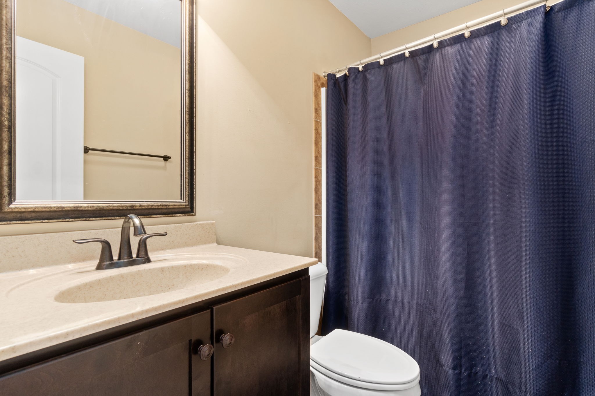 3784 Suiter Road Clarksville, TN 37040 - Photo 23 of 28 a bathroom with a sink a toilet a mirror and shower curtain
