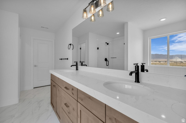 2901 North Scarlet Road, Unit 146 Eagle Mountain, UT 84005 - Photo 18 of 19 Large primary bathroom with double vanities, soaker tub, walk-in shower with euro glass, upgraded matte black hardware and fixtures, light stained wood cabinetry, Quartz countertops etc.