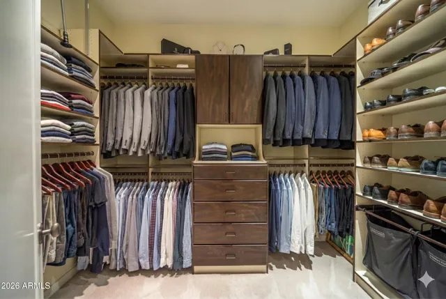 a view of walk in closet with clothes and shoes