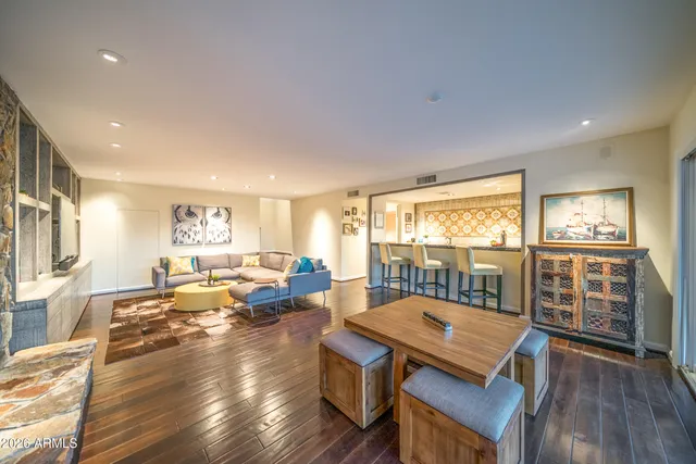 a living room with furniture a wooden floor and a large window