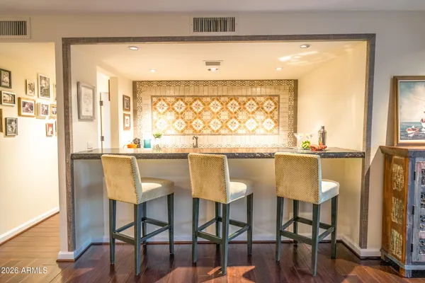 a kitchen with stainless steel appliances a dining table chairs and a large window