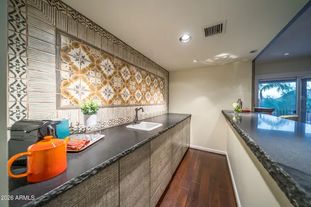 a large kitchen with granite countertop a large counter top a sink and appliances