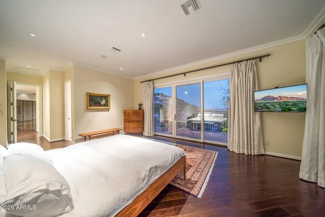 a spacious bedroom with a large bed and a wooden floor