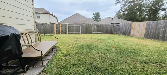 a view of a backyard with table and chairs with wooden fence