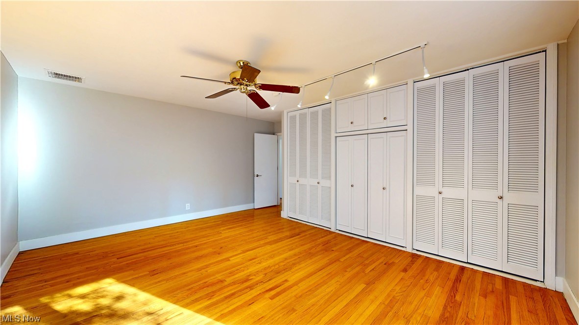 1976 Ridgewood Road Akron, OH 44313 - Photo 20 of 35 Bedroom featuring ceiling fan, light wood-type flooring, and two closets