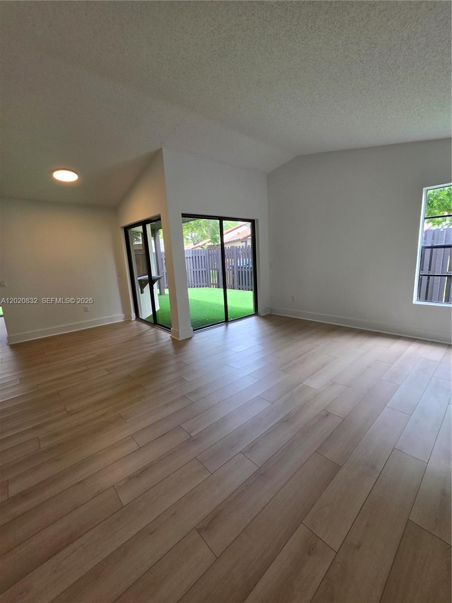 15240 Southwest 45th Terrace, Unit 54F Miami, FL 33185 - Photo 16 of 48 a view of an empty room with window and wooden floor