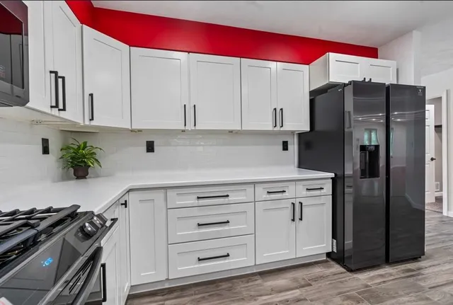 a kitchen with stainless steel appliances a refrigerator stove and cabinets