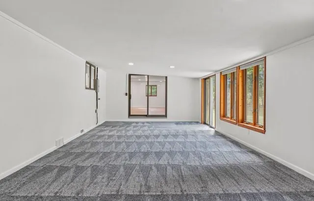 a view of an empty room with window and closet area