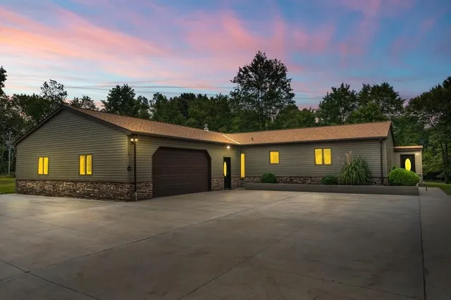 a front view of house with yard and trees in the background