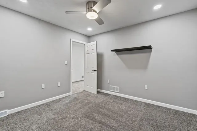 an empty room with closet and a chandelier fan