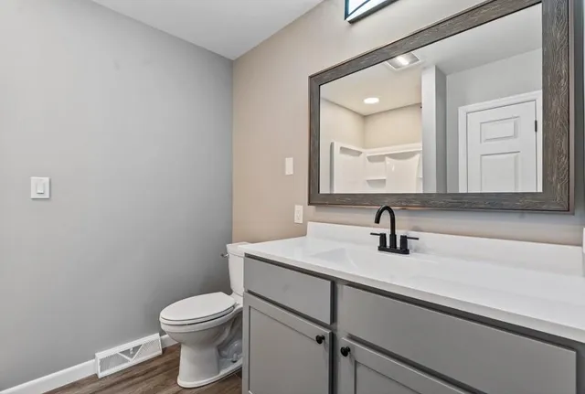 a bathroom with a toilet sink and mirror