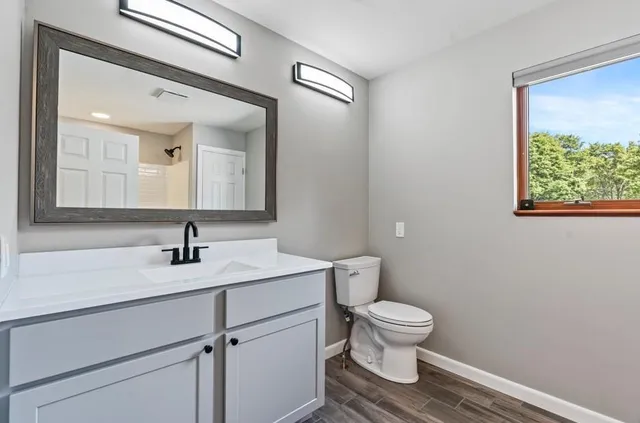 a bathroom with a toilet a sink and mirror