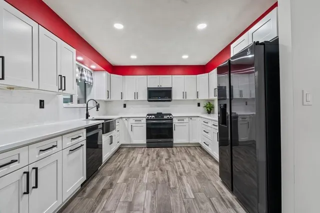 a kitchen with stainless steel appliances a refrigerator sink and cabinets