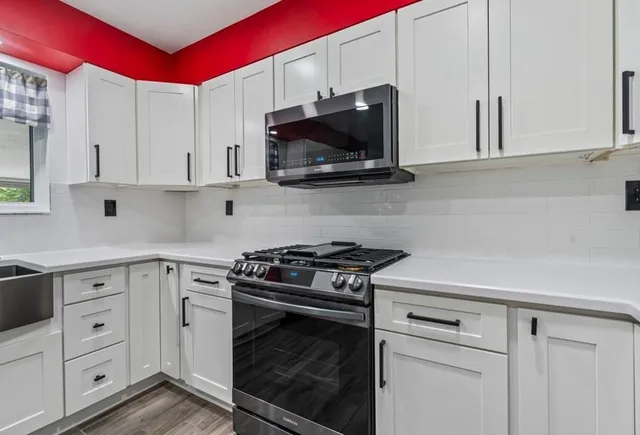 a kitchen with white cabinets and stainless steel appliances