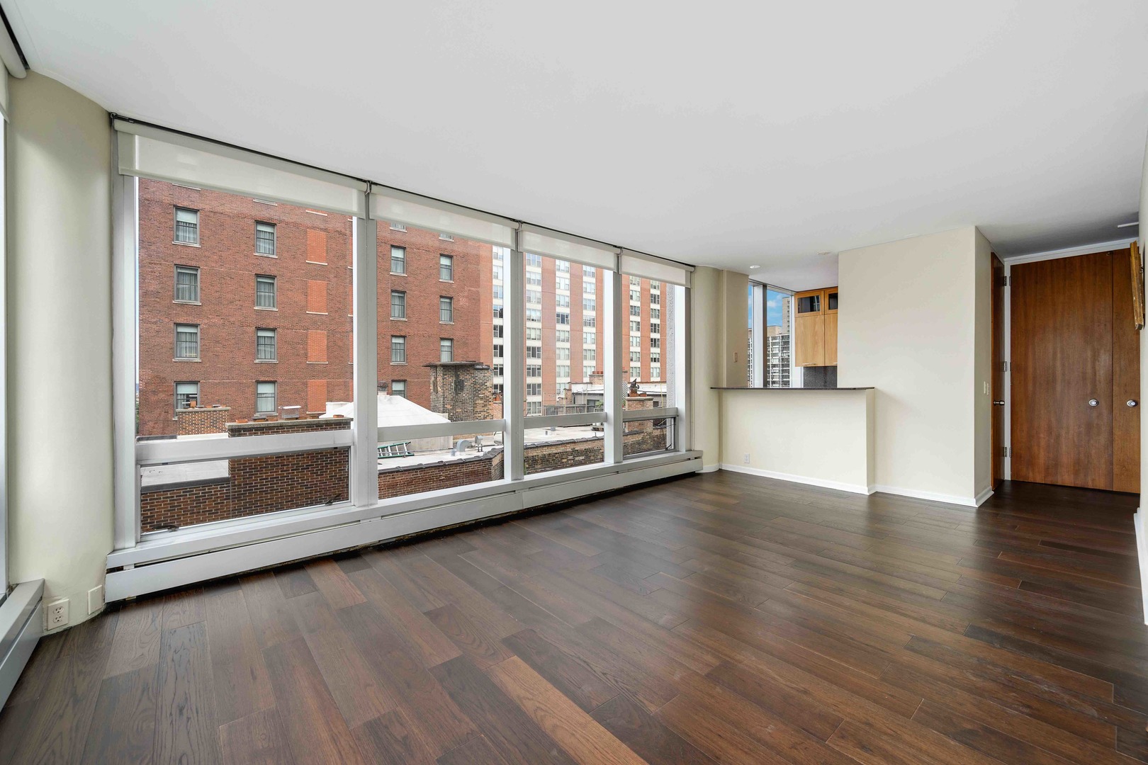 1300 North Astor Street, Unit 10D Chicago, IL 60610 - Photo 6 of 25 a view of an empty room with a window and wooden floor