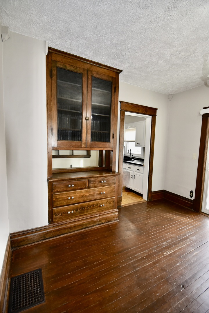 203 South Denver Street Bloomington, IL 61701 - Photo 28 of 54 a view of an empty room with wooden floor and a cabinet